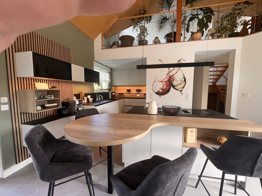 Cuisine sur mesure avec îlot et table arrondie dans une pièce étroite à Daubensand